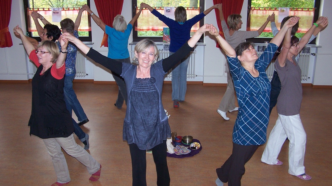Gruppe beim meditativen Tanz, die Hände im Kreis erhoben